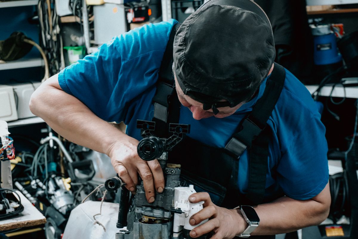 Technik opravuje práčku priamo u zákazníka doma